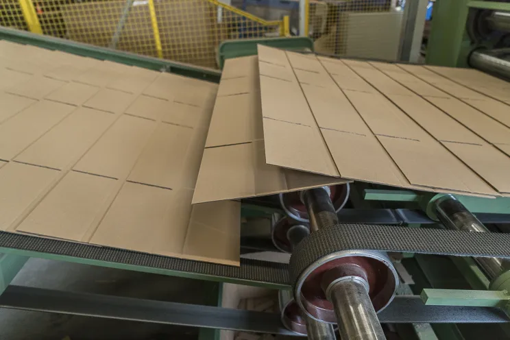 Kartonnen dozen worden gesneden door de machine bij Doosopmaat.nl